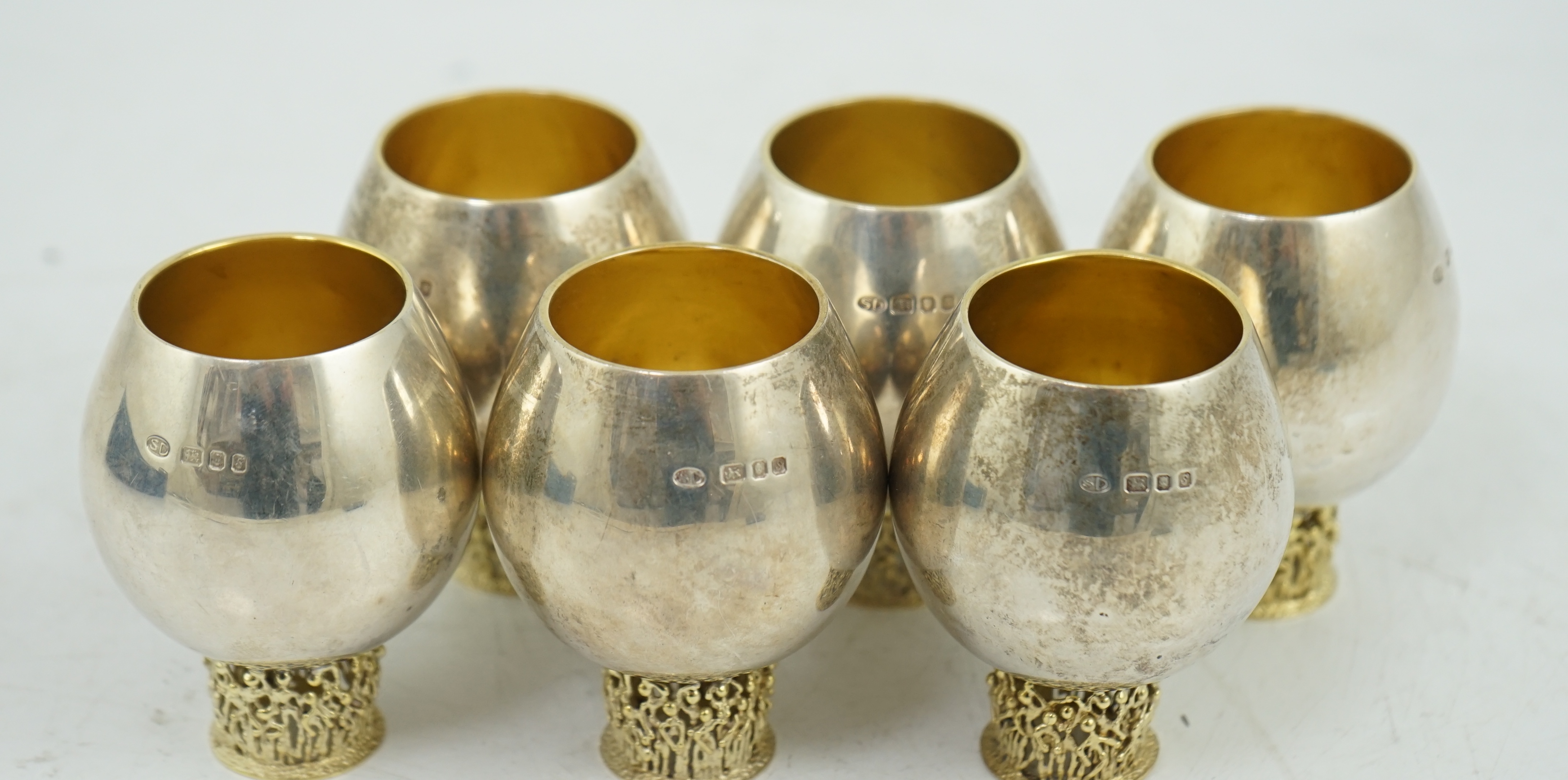 A set of six Elizabeth II Stuart Devlin parcel gilt silver balloon shaped pedestal tots